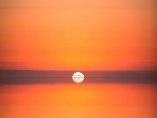 Ein weiter Horizont im Sonnenuntergang, der eine verträumte Atmosphäre versprüht.
